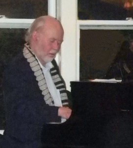 Bob Pilsbury, wearing piano scarf, playing piano