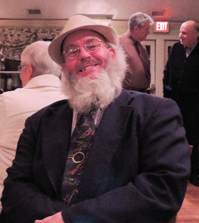 Al Bernard in suit and tie, white hat, long white beard, smiling at camera
